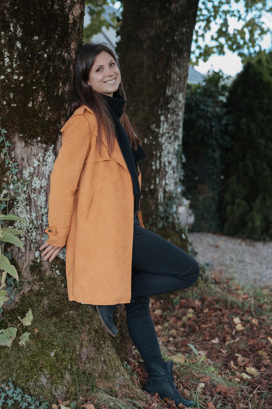 Ramona Sabatino lachend an einen Baum gelehnt
